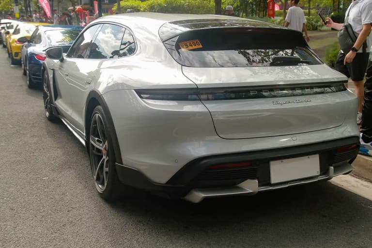 Grey Porsche Taycan Turbo Cross Turismo rear view at a car meet showing the Turbo badge