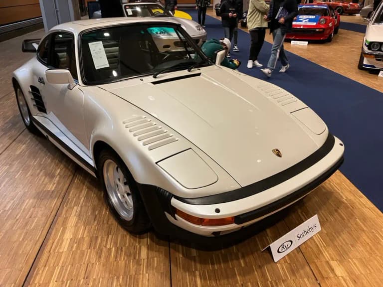 White 1989 Porsche 911 Turbo Flachbau with pop-up headlight covers and slant nose, front three-quarter view