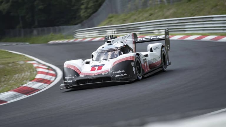 Porsche 919 Hybrid Evo cornering on a race track past red and white curbs