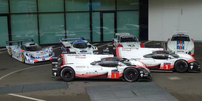 Regulated Porsche 919 Hybrid race cars displayed beside the 919 Hybrid Evo at the Porsche Museum in Stuttgart