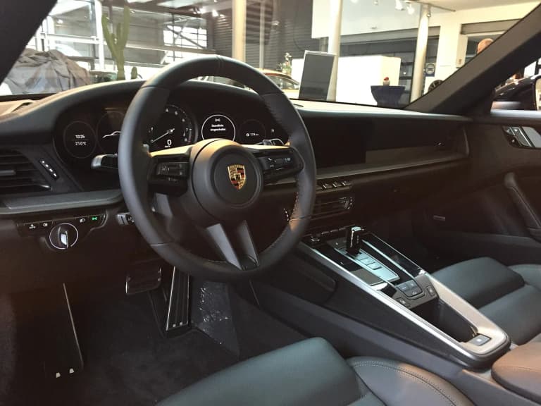 Porsche 992 dashboard with central analog tachometer, touchscreen and leather seats