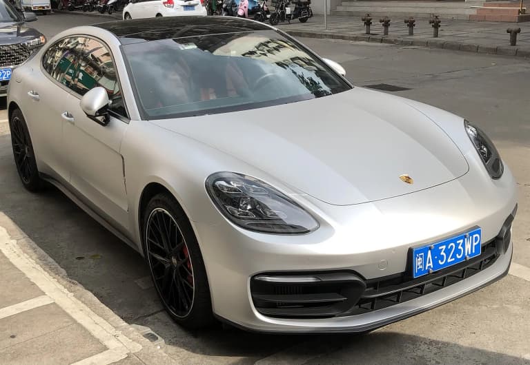 White second-generation Porsche Panamera 4, type 971, parked at a curb.