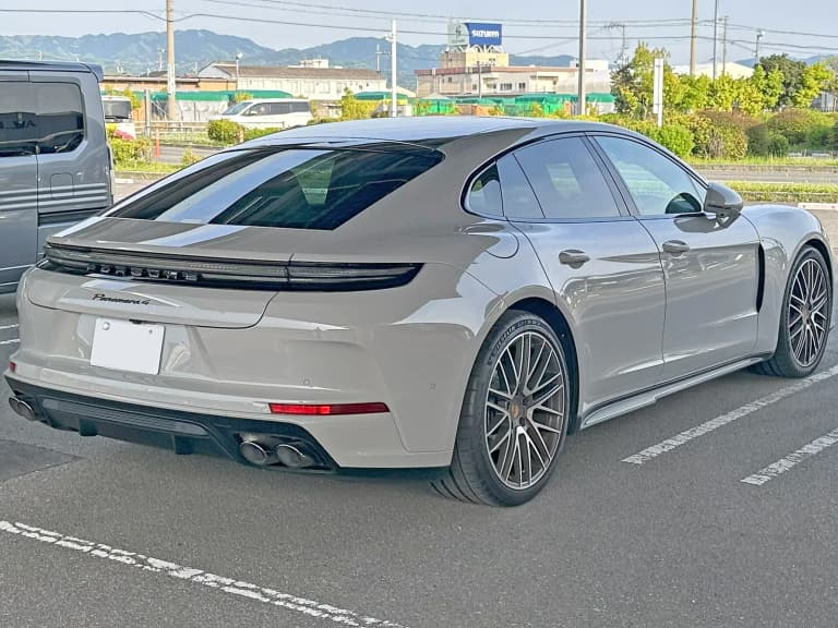 Rear three-quarter view of a silver current-generation Porsche Panamera 4, type 972.