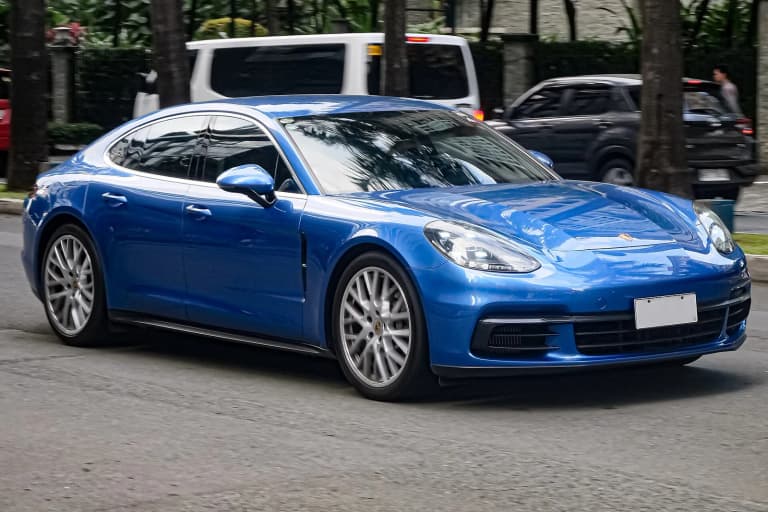 Sapphire Blue Porsche Panamera 971 4S driving on a street.