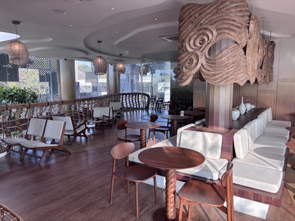Upstairs lounge seating at Realm Bangkok with a woven art installation