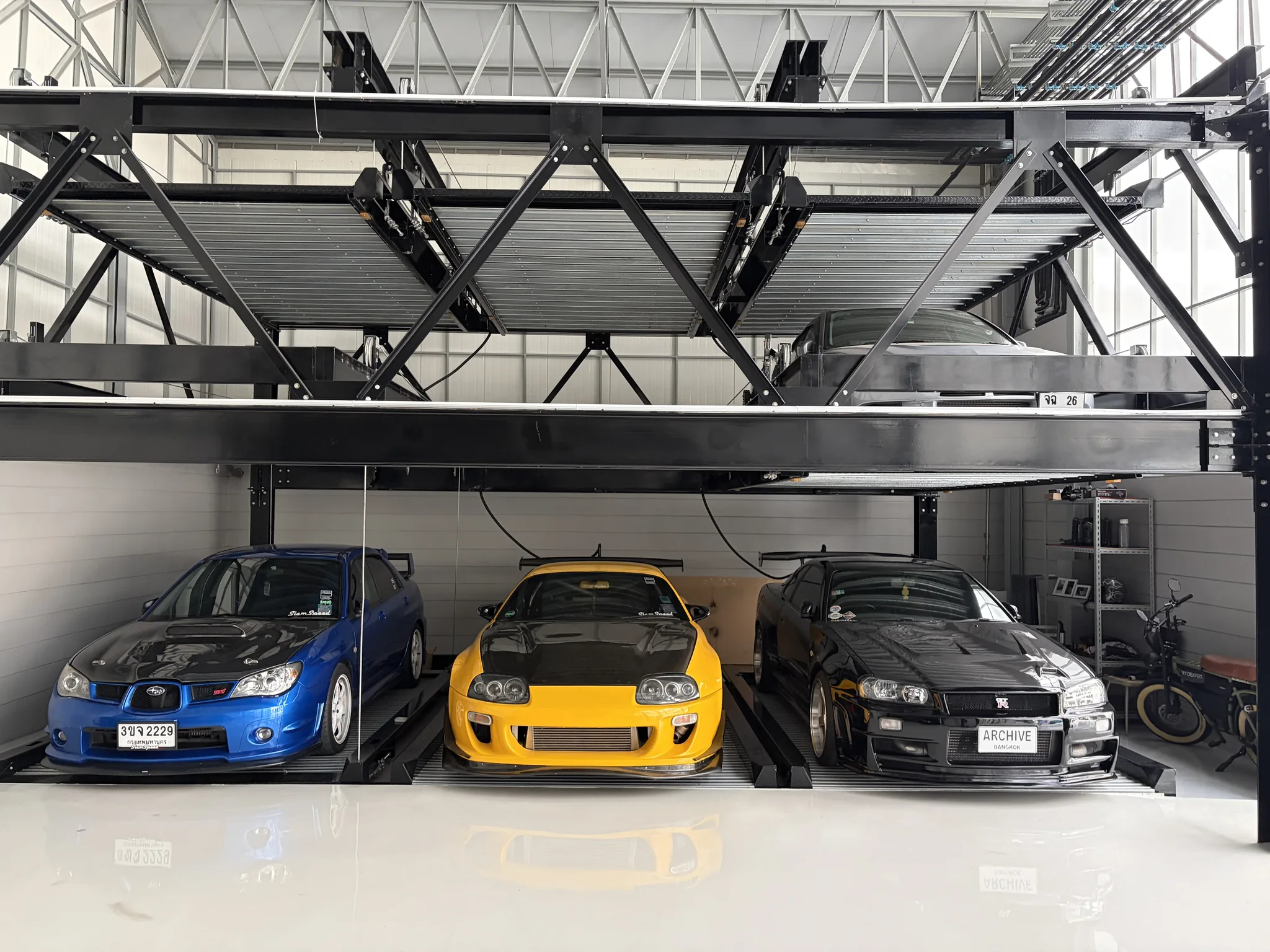 Three cars parked beneath the Archive Coffee garage lift