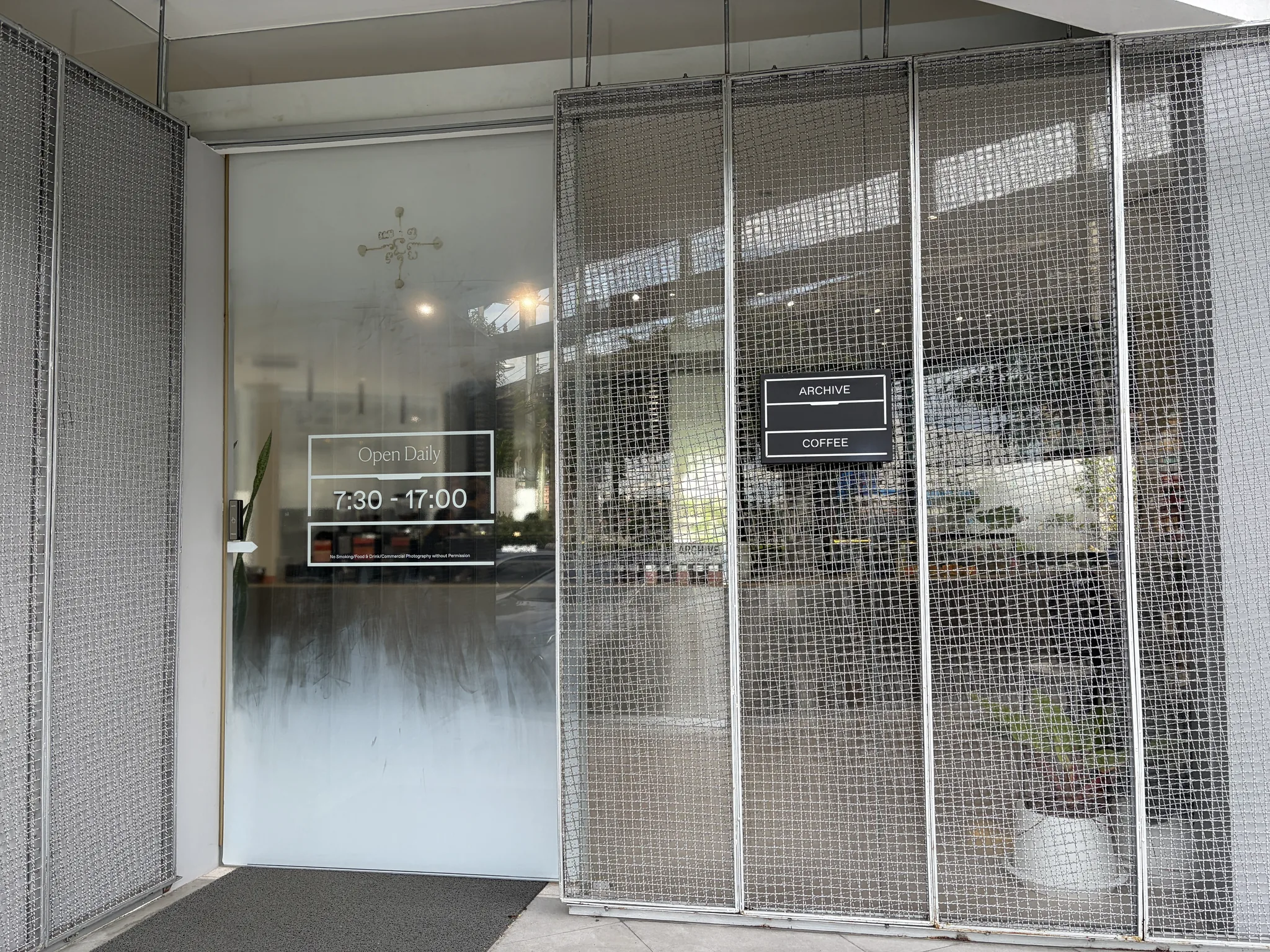 Archive Coffee entrance behind metal mesh doors