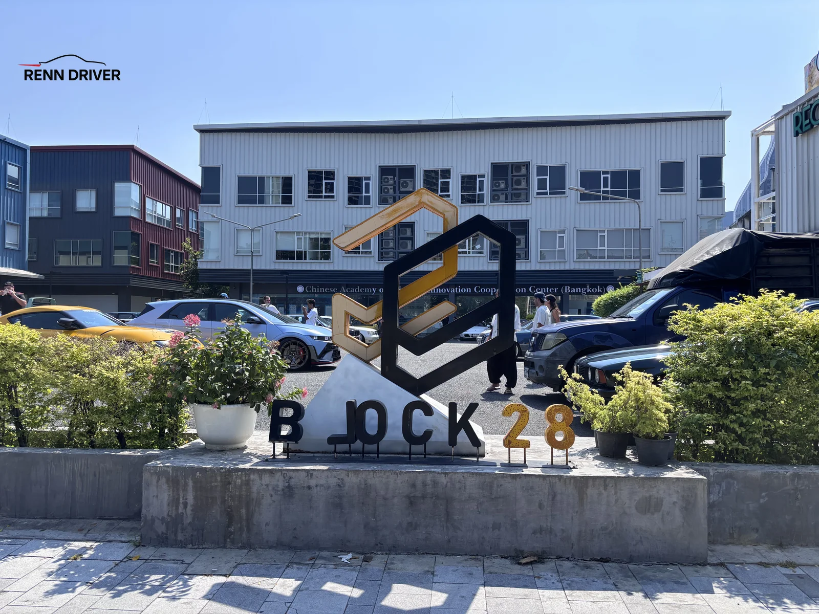 Block 28 sculpture sign with cars parked behind it