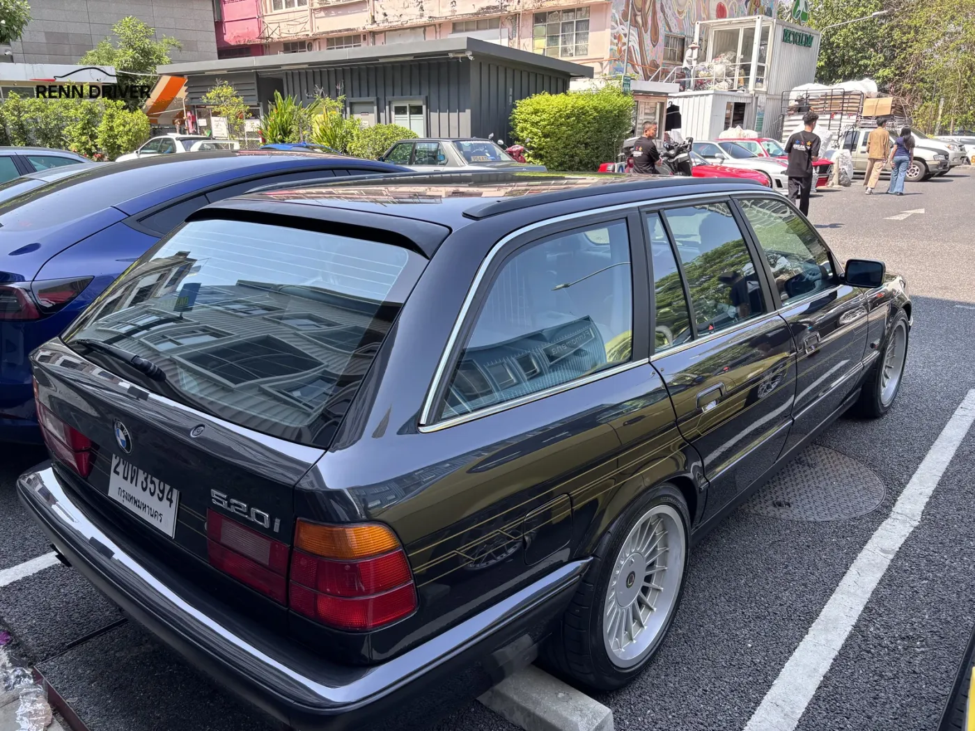 Black BMW E34 520i Touring wagon parked at a car meet